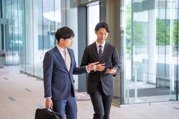 歩きながら打ち合わせをする男性ビジネスマン