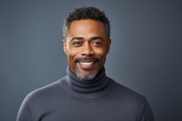 Fototapeta premium Portrait of a content afro-american man in his 40s wearing a classic turtleneck sweater while standing against soft gray background