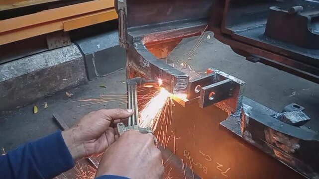 A worker is doing iron cutting work using a cutting torch