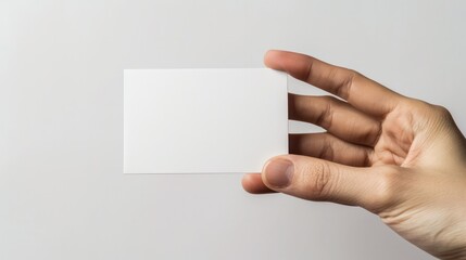 A hand holding a white business card