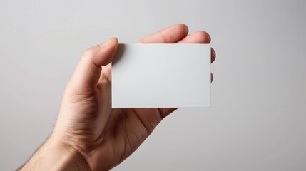 A hand holding a white business card