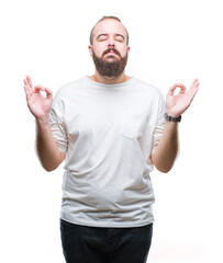 Fototapeta premium Young caucasian hipster man wearing casual t-shirt over isolated background relax and smiling with eyes closed doing meditation gesture with fingers. Yoga concept.