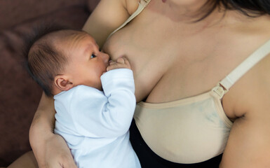 Mother breastfeeding her little baby boy in her arms. The concept of breastfeeding.