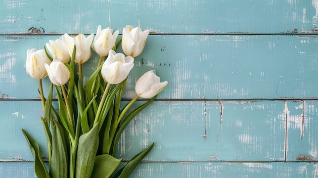 Spring flower bouquet with white tulips on light blue wooden backdrop