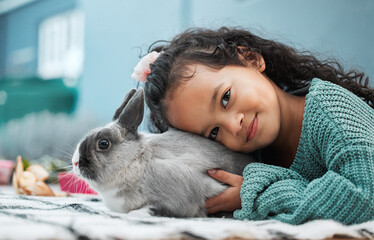 Girl, child and rabbit in home portrait for love and emotional support, pet care and hug in...