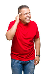 Fototapeta premium Middle age arab man over isolated background smiling with hand over ear listening an hearing to rumor or gossip. Deafness concept.
