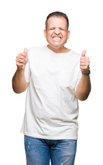 Middle age arab man wearig white t-shirt over isolated background excited for success with arms raised celebrating victory smiling. Winner concept.