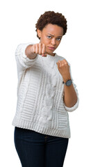 Beautiful young african american woman wearing sweater over isolated background Punching fist to fight, aggressive and angry attack, threat and violence