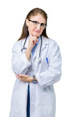 Middle age mature doctor woman wearing medical coat over isolated background with hand on chin thinking about question, pensive expression. Smiling with thoughtful face. Doubt concept.