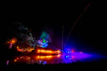 Outdoor night music party at the lake with lights and decorations