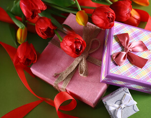 gift boxes and flowers on green background
