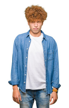 Young handsome man with afro hair wearing denim jacket skeptic and nervous, frowning upset because of problem. Negative person.