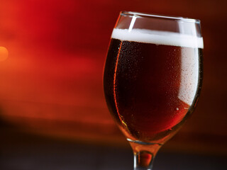 Beer glass on a red background. Amber Ale, copy space