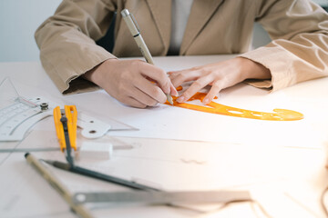 The fashion designer, a skilled woman dressmaker, used a ruler as a crucial tool to create a...