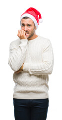 Young handsome man wearing santa claus hat over isolated background looking stressed and nervous with hands on mouth biting nails. Anxiety problem.