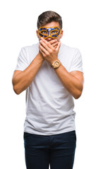 Young handsome man wearing carnival mask over isolated background shocked covering mouth with hands for mistake. Secret concept.