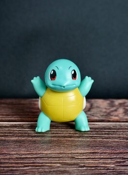 Jakarta, Indonesia - July 3rd, 2024 - Pokemon animal turtle squirtle character Mcdonalds happy meals bonus. Children or kids toys figure object isolated on vertical dark wooden surface background.