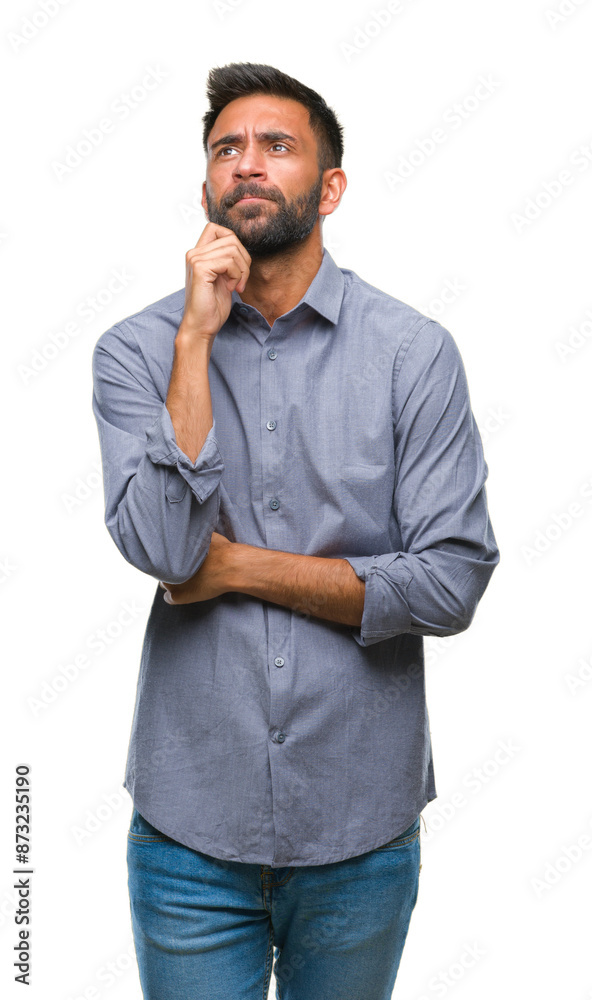 Poster Adult hispanic man over isolated background with hand on chin thinking about question, pensive expression. Smiling with thoughtful face. Doubt concept.