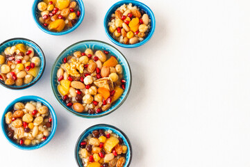 Traditional Turkish Dessert Ashure or Noah's Pudding in stylish ceramic bowl on white surface.Turkish Cuisine