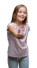 Fototapeta premium Young beautiful girl over isolated background smiling friendly offering handshake as greeting and welcoming. Successful business.