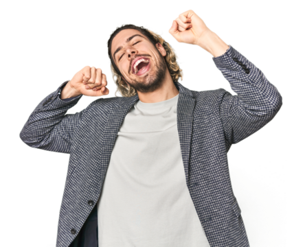 Young businessman in casual blazer celebrating a special day, jumps and raise arms with energy.