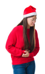 Young Chinese woman over isolated background wearing christmas hat with hand on stomach because nausea, painful disease feeling unwell. Ache concept.