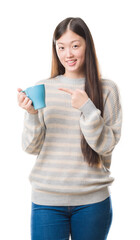 Young Chinese woman over isolated background driking cup of coffee very happy pointing with hand and finger