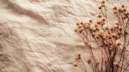 Vintage-style floral background with dried flax plant bunch on pure linen fabric, featuring copy space.