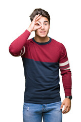 Fototapeta premium Young handsome man over isolated background doing ok gesture with hand smiling, eye looking through fingers with happy face.