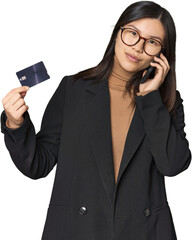 Young businesswoman with credit card on call in studio