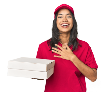 Latina delivering pizza, studio setup laughs out loudly keeping hand on chest.