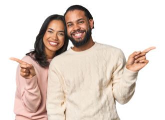 Young Latino couple in studio pointing to different copy spaces, choosing one of them, showing with finger.