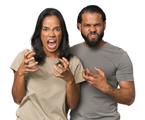 Young Latino couple in studio screaming with rage.