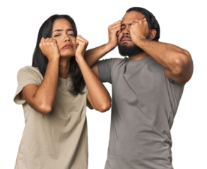Young Latino couple in studio crying, unhappy with something, agony and confusion concept.