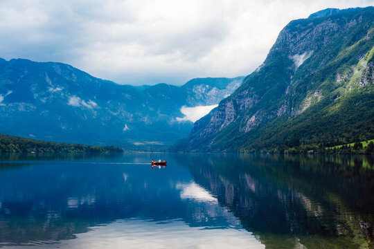 Beautiful view of Bohinj lake and lonely boat on the background of the mountains, Slovenia