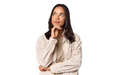 Portrait of a young Filipino woman looking sideways with doubtful and skeptical expression.