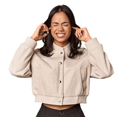 Young filipino woman covering ears with fingers, stressed and desperate by a loudly ambient.