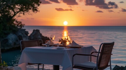 Elegant dinner setup for two, with a stunning view of the sea at sunset