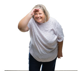 Senior plus size caucasian woman over isolated background very happy and smiling looking far away with hand over head. Searching concept.