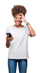 Young african american woman using smartphone over isolated background with happy face smiling doing ok sign with hand on eye looking through fingers