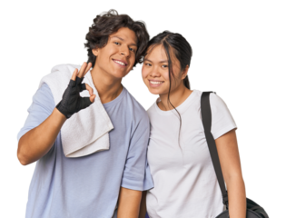Young interracial athletic couple in studio cheerful and confident showing ok gesture.