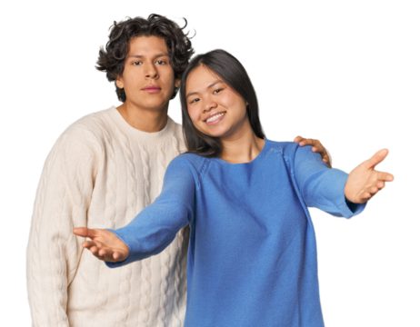 Young interracial couple in studio showing a welcome expression.