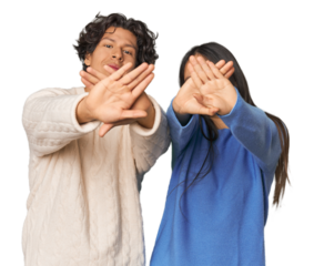 Young interracial couple in studio doing a denial gesture