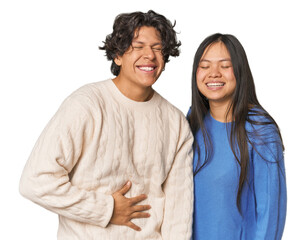 Young interracial couple in studio touches tummy, smiles gently, eating and satisfaction concept.