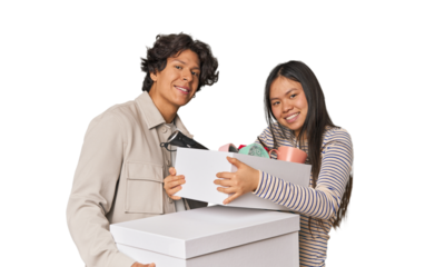 Multiracial young couple with moving boxes in studio