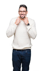 Fototapeta premium Young handsome man wearing glasses over isolated background Smiling with open mouth, fingers pointing and forcing cheerful smile
