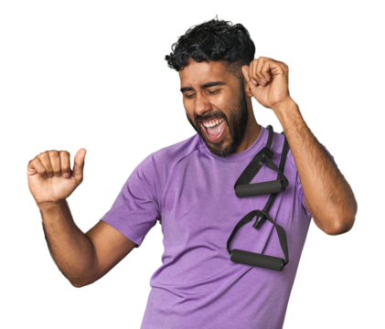 Hispanic male in sportswear with bands in studio dancing and having fun.