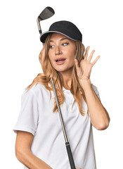 Young blonde golfer in studio trying to listening a gossip.