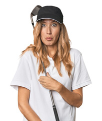 Young blonde golfer in studio shrugs shoulders and open eyes confused.
