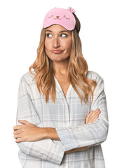 Blonde in pajamas with sleep mask dreaming of achieving goals and purposes